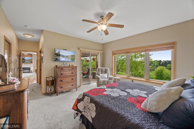 6831 Centerville Rd, Centerville, MN 55038 - bedroom featuring carpet, access to exterior, a ceiling fan, and a fireplace