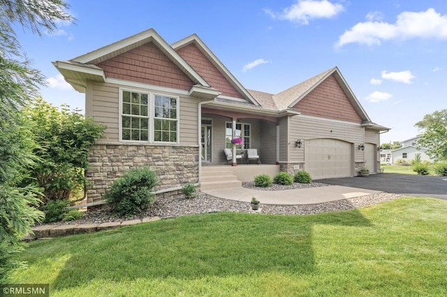 6831 Centerville Rd, Centerville, MN 55038 - craftsman-style home with covered porch, stone siding, asphalt driveway, a front lawn, and a garage