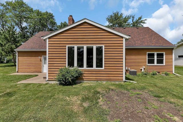 1044 Borgert Ave, Saint Cloud, MN 56303 - rear view of house with a yard, a shingled roof, and a chimney