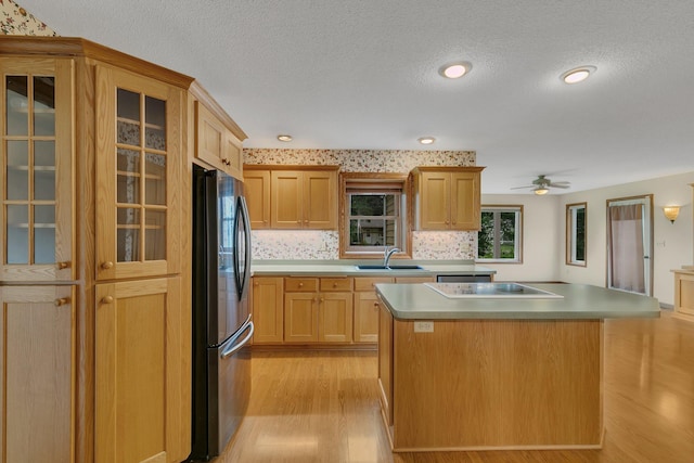 1044 Borgert Ave, Saint Cloud, MN 56303 - kitchen with freestanding refrigerator, black electric stovetop, a textured ceiling, light wood-style floors, and a center island