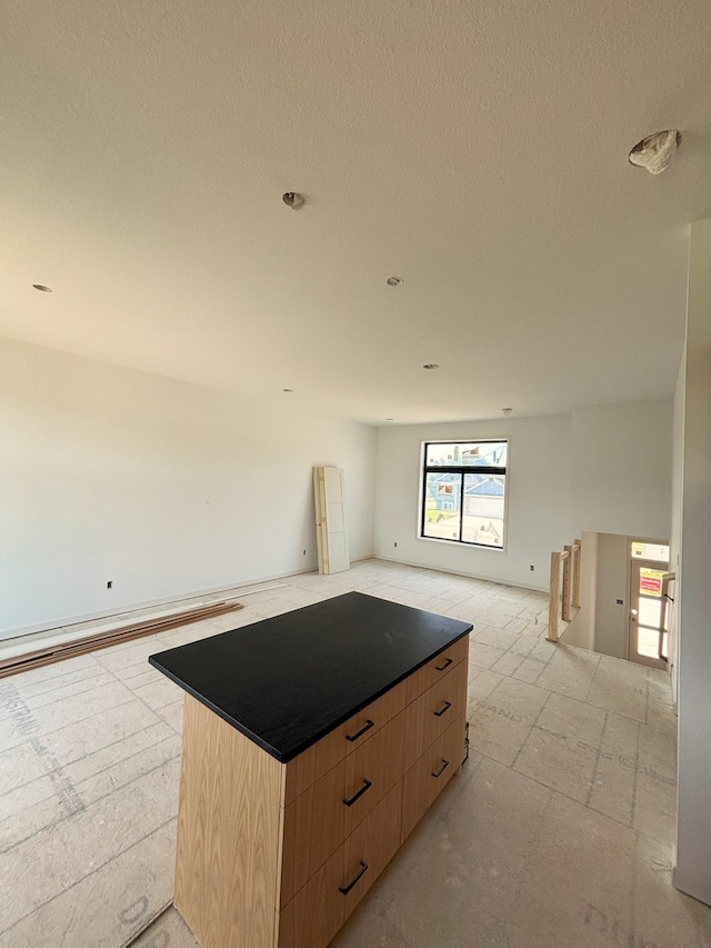 3676 Meadow Sage Ct SE, Rochester, MN 55904 - kitchen with open floor plan, light brown cabinetry, a kitchen island, a textured ceiling, and modern cabinets