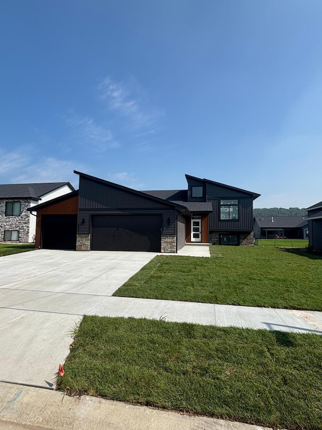 3676 Meadow Sage Ct SE, Rochester, MN 55904 - view of front facade with stone siding, a garage, concrete driveway, a front yard, and board and batten siding