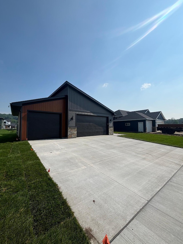 3676 Meadow Sage Ct SE, Rochester, MN 55904 - view of front of property featuring driveway, stone siding, a front lawn, an attached garage, and board and batten siding