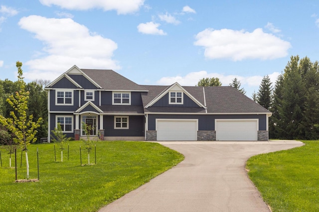 4965 250th St, Elko New Market, MN 55020 - craftsman-style house featuring driveway, a front yard, stone siding, and an attached garage
