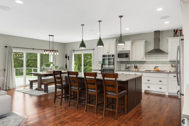 4965 250th St, Elko New Market, MN 55020 - kitchen with wall chimney range hood, stainless steel appliances, backsplash, dark wood-style floors, and a kitchen island