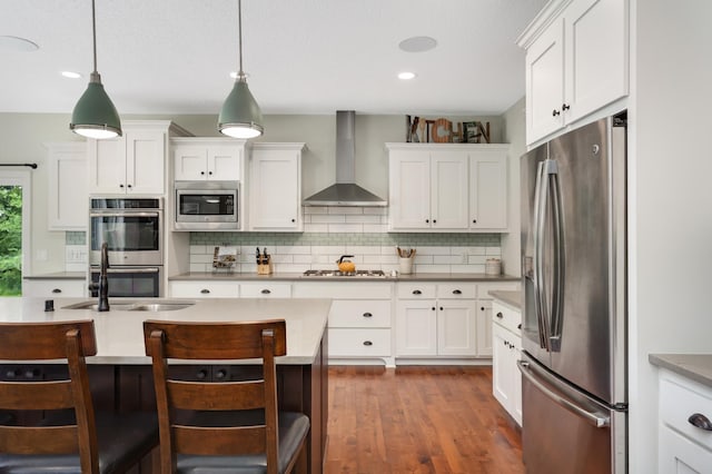 4965 250th St, Elko New Market, MN 55020 - kitchen featuring appliances with stainless steel finishes, wall chimney range hood, tasteful backsplash, white cabinetry, and a breakfast bar area