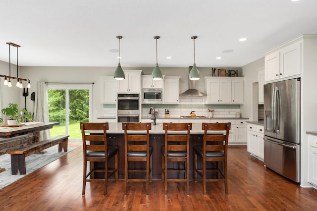 4965 250th St, Elko New Market, MN 55020 - kitchen featuring stainless steel appliances, wall chimney range hood, decorative backsplash, white cabinets, and dark wood-type flooring