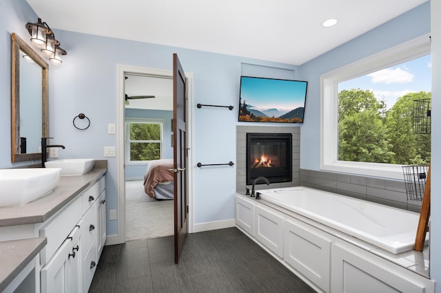 4965 250th St, Elko New Market, MN 55020 - full bath with double vanity, a garden tub, ensuite bathroom, recessed lighting, and a glass covered fireplace