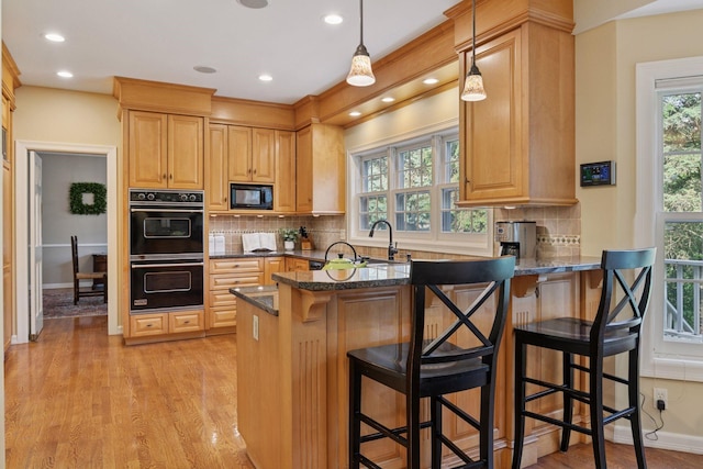 10636 Purdey Rd, Eden Prairie, MN 55347 - kitchen featuring black appliances, light wood-type flooring, plenty of natural light, a peninsula, and recessed lighting