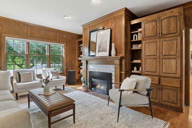 10636 Purdey Rd, Eden Prairie, MN 55347 - living area with built in features, wooden walls, a fireplace with flush hearth, and wood finished floors