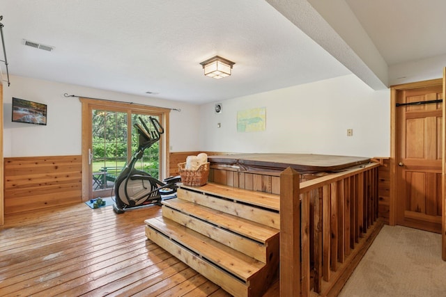10636 Purdey Rd, Eden Prairie, MN 55347 - interior space with a wainscoted wall, hardwood / wood-style floors, wooden walls, and a textured ceiling