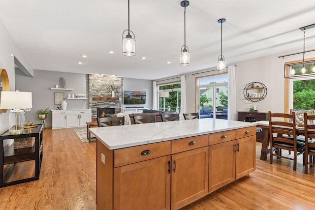 2061 Langston Ln NE, Saint Michael, MN 55376 - kitchen with a fireplace, light wood-type flooring, hanging light fixtures, a center island, and recessed lighting