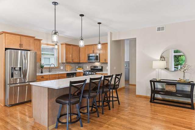 2061 Langston Ln NE, Saint Michael, MN 55376 - kitchen featuring appliances with stainless steel finishes, light wood-type flooring, tasteful backsplash, and plenty of natural light