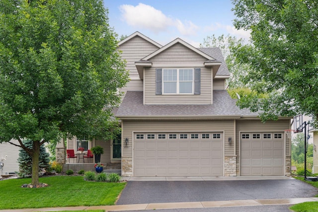 2061 Langston Ln NE, Saint Michael, MN 55376 - view of front of home featuring stone siding, a front yard, roof with shingles, a garage, and asphalt driveway