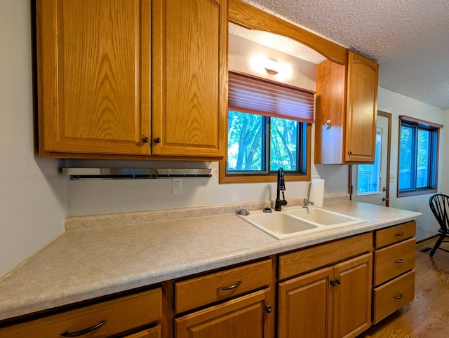 314 11th St, Montevideo, MN 56265 - kitchen with light countertops, a textured ceiling, dark wood-style floors, and brown cabinetry