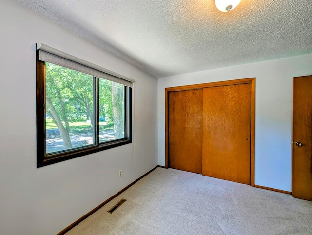 314 11th St, Montevideo, MN 56265 - unfurnished bedroom featuring light colored carpet, a textured ceiling, and a closet