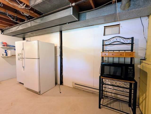 314 11th St, Montevideo, MN 56265 - below grade area with freestanding refrigerator, baseboard heating, and carpet