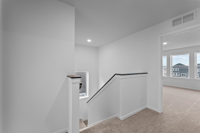 hallway featuring an upstairs landing, light colored carpet, and recessed lighting