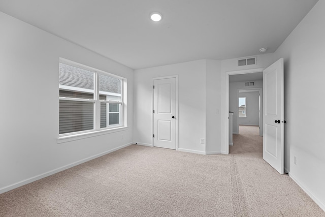 unfurnished bedroom featuring light colored carpet and baseboards