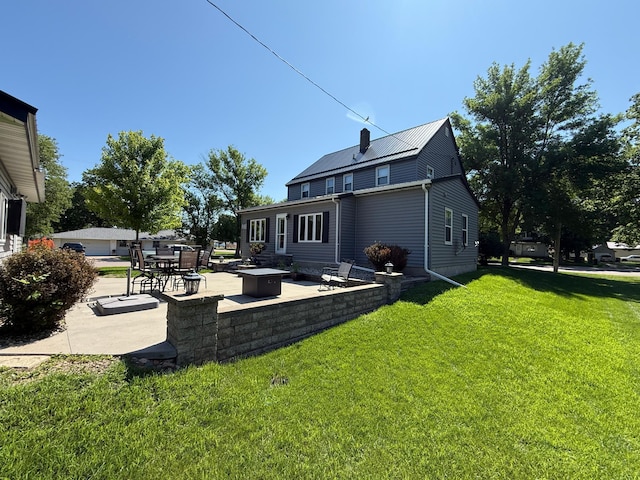 411 Vernon Ave, Morgan, MN 56266 - rear view of property with a patio, a lawn, a metal roof, and a chimney