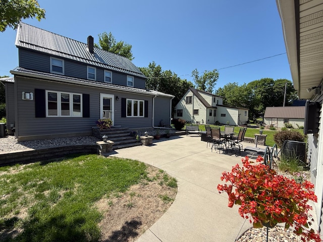 411 Vernon Ave, Morgan, MN 56266 - rear view of property featuring a patio area, a metal roof, a lawn, and a chimney