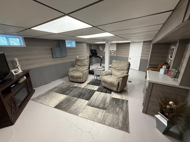 411 Vernon Ave, Morgan, MN 56266 - living room featuring wooden walls, finished concrete floors, and a drop ceiling