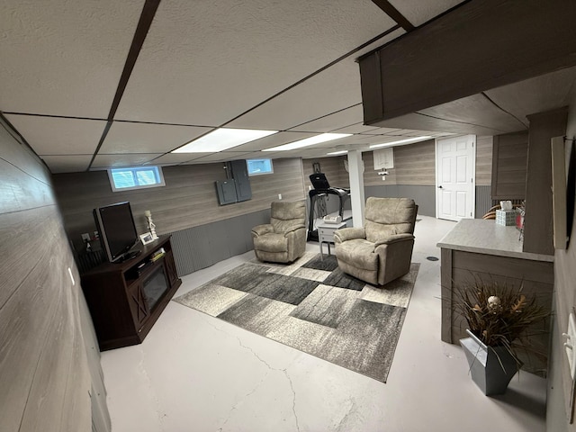 411 Vernon Ave, Morgan, MN 56266 - living area featuring wooden walls, concrete floors, and a drop ceiling