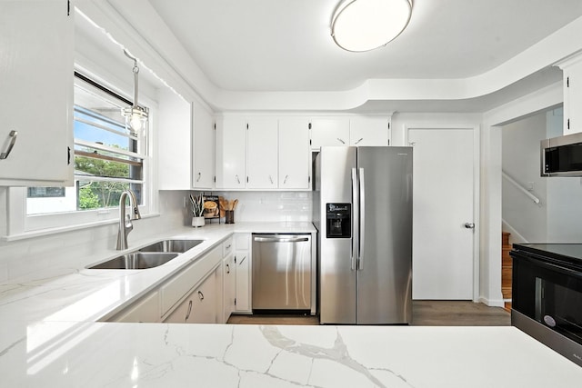 1464 Kent St, Saint Paul, MN 55117 - kitchen with appliances with stainless steel finishes, white cabinets, light stone counters, tasteful backsplash, and wood finished floors