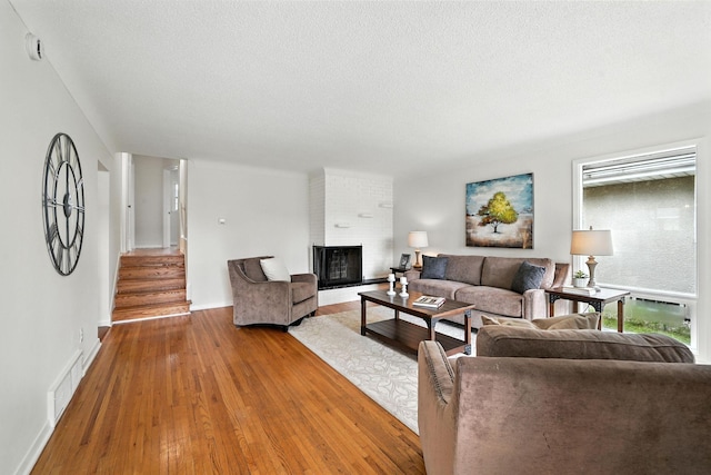 1464 Kent St, Saint Paul, MN 55117 - living area featuring hardwood / wood-style flooring, a textured ceiling, stairway, and a fireplace