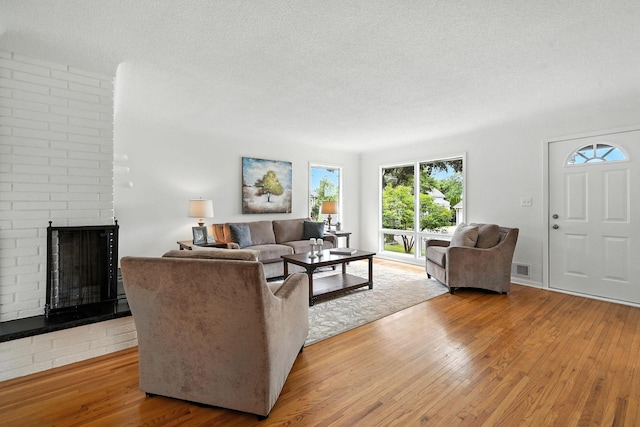 1464 Kent St, Saint Paul, MN 55117 - living area featuring hardwood / wood-style flooring, a fireplace, and a textured ceiling