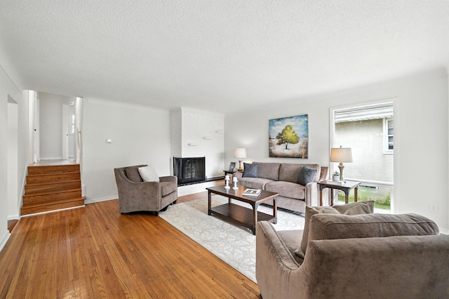 1464 Kent St, Saint Paul, MN 55117 - living area with hardwood / wood-style flooring, a textured ceiling, stairway, and a fireplace