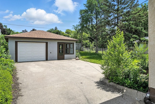 1464 Kent St, Saint Paul, MN 55117 - view of front facade featuring a detached garage, stucco siding, driveway, an outdoor structure, and a shingled roof