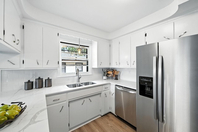 1464 Kent St, Saint Paul, MN 55117 - kitchen with appliances with stainless steel finishes, tasteful backsplash, white cabinetry, light stone counters, and light wood-type flooring