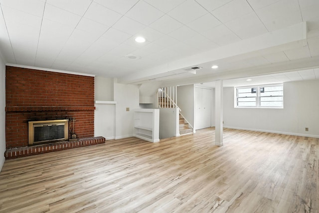 1464 Kent St, Saint Paul, MN 55117 - unfurnished living room featuring wood finished floors, stairs, a brick fireplace, and recessed lighting