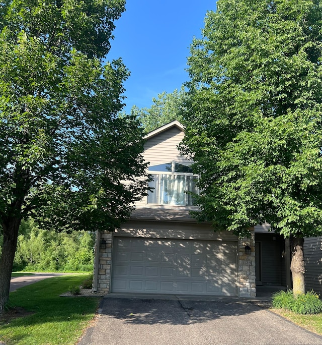 1129 Willow Trl, Farmington, MN 55024 - view of property hidden behind natural elements featuring stone siding, driveway, a garage, and a front lawn
