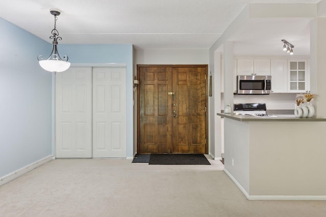 6650 Vernon Ave S Unit 111, Edina, MN 55436 - kitchen featuring stainless steel microwave, stove, white cabinetry, carpet flooring, and glass insert cabinets