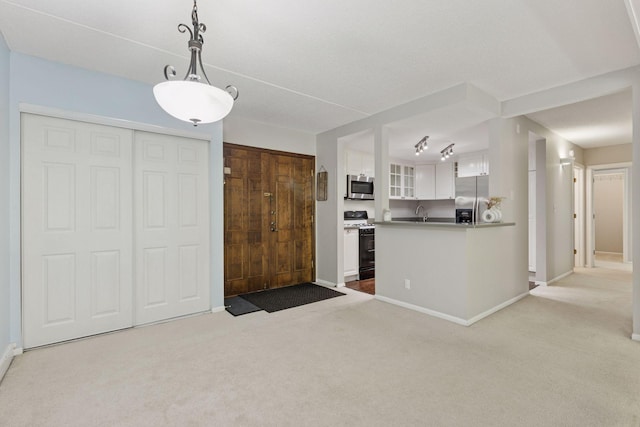 6650 Vernon Ave S Unit 111, Edina, MN 55436 - kitchen featuring stainless steel appliances, carpet floors, white cabinets, glass insert cabinets, and decorative light fixtures