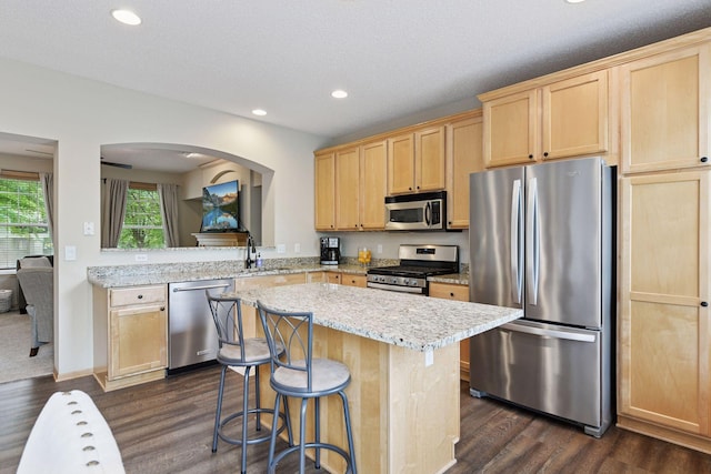 8356 Townsend Dr, Eden Prairie, MN 55344 - kitchen with appliances with stainless steel finishes, light brown cabinets, dark wood-style flooring, a center island, and recessed lighting
