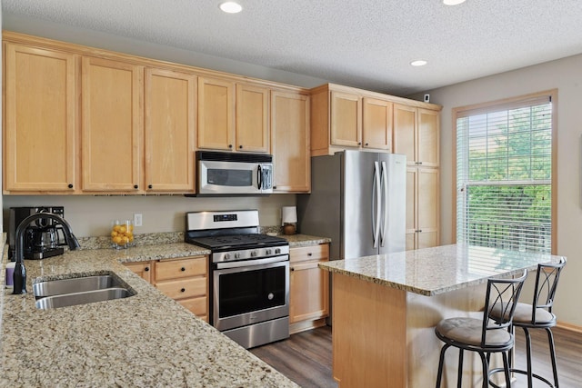 8356 Townsend Dr, Eden Prairie, MN 55344 - kitchen with appliances with stainless steel finishes, light brown cabinets, dark wood-type flooring, a breakfast bar, and recessed lighting