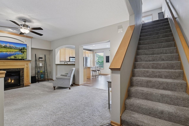 8356 Townsend Dr, Eden Prairie, MN 55344 - carpeted living room with a ceiling fan, stairway, and a high end fireplace