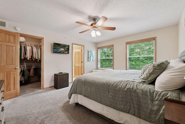 8356 Townsend Dr, Eden Prairie, MN 55344 - bedroom featuring a walk in closet, light carpet, a closet, a textured ceiling, and a ceiling fan