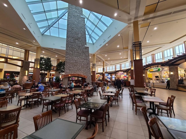 8356 Townsend Dr, Eden Prairie, MN 55344 - tiled dining space with a towering ceiling, ornate columns, and a multi sided fireplace