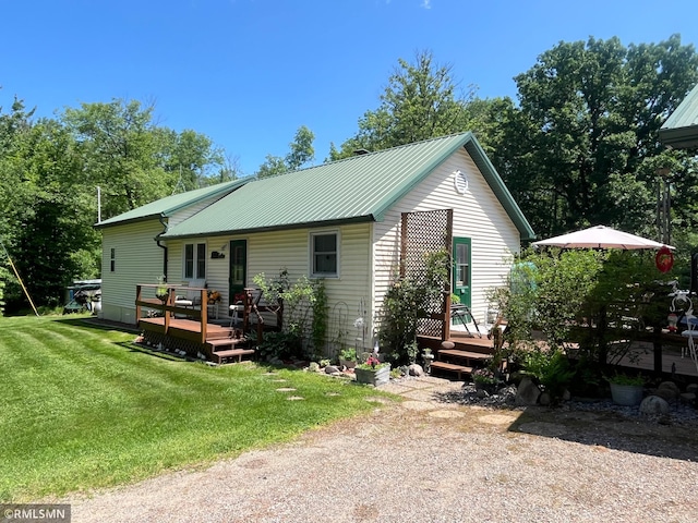 37452 Deer St, Aitkin, MN 56431 - back of property featuring a deck, a lawn, and a metal roof