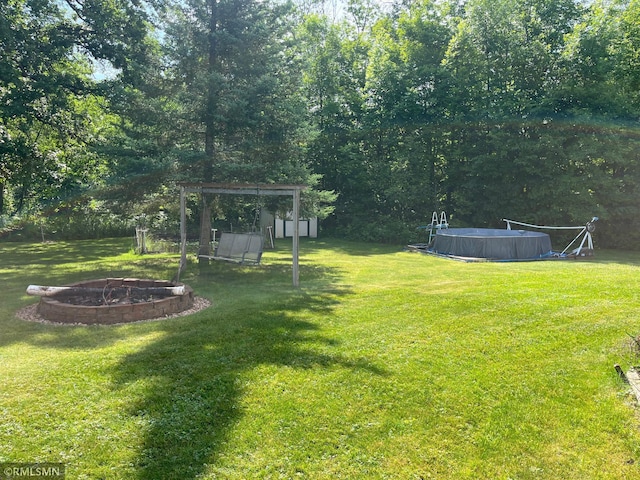 37452 Deer St, Aitkin, MN 56431 - view of grassy yard featuring an outdoor fire pit, a storage shed, and an outdoor pool