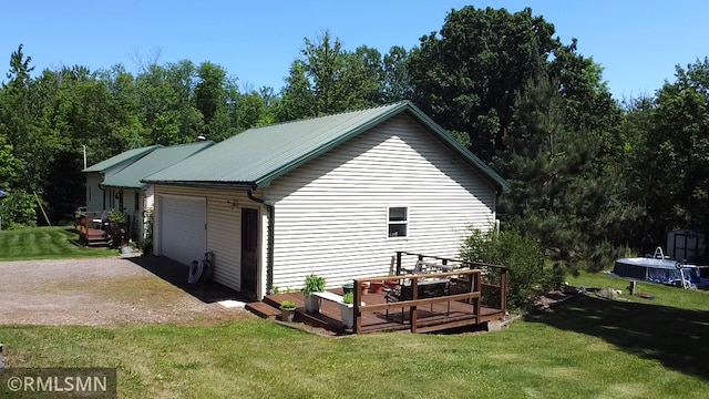 37452 Deer St, Aitkin, MN 56431 - view of side of home featuring a garage, a lawn, dirt driveway, and a storage shed