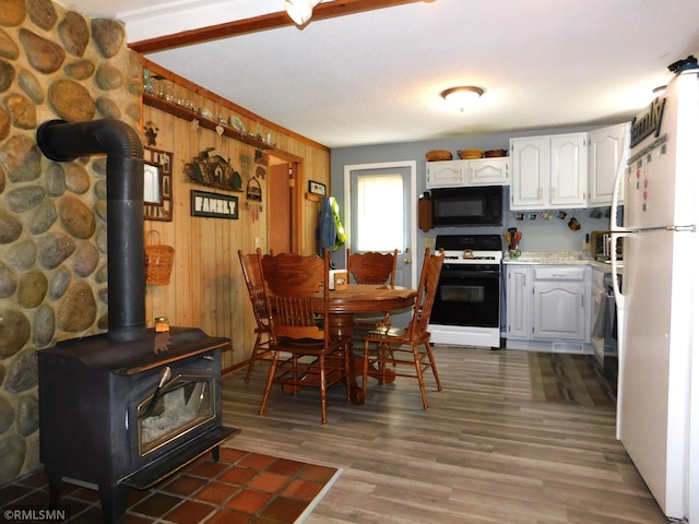 37452 Deer St, Aitkin, MN 56431 - dining area featuring a wood stove, dark wood-type flooring, and wood walls