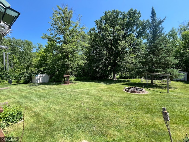 37452 Deer St, Aitkin, MN 56431 - view of green lawn with a shed and a fire pit