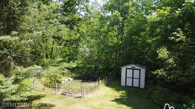 37452 Deer St, Aitkin, MN 56431 - view of green lawn featuring a shed and a wooded view