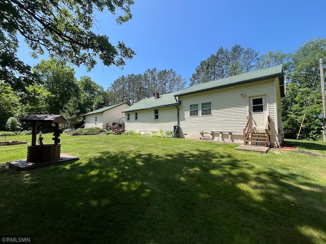 37452 Deer St, Aitkin, MN 56431 - rear view of house with entry steps, a yard, and a metal roof
