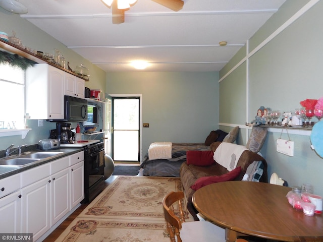 37452 Deer St, Aitkin, MN 56431 - kitchen featuring black appliances, white cabinetry, ceiling fan, and dark countertops
